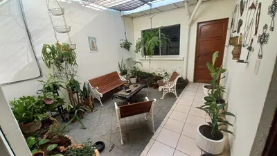 a patio with a bench and a bunch of plants at Casa Flor Blanca in San Salvador