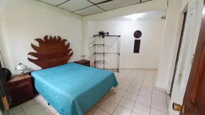 a bedroom with a bed with a blue blanket on it at Casa Flor Blanca in San Salvador