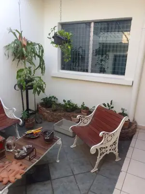 a patio with a bench and a table and a window at Casa Flor Blanca in San Salvador