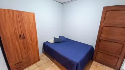 a bedroom with a blue bed and a wooden cabinet at Casa Flor Blanca in San Salvador