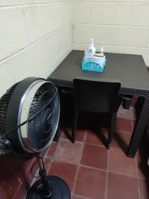 a table with a fan in front of a table with a tableablish at KameHouse Backpackers in San Salvador