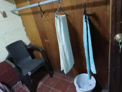 a bathroom with a toilet and a chair in it at KameHouse Backpackers in San Salvador