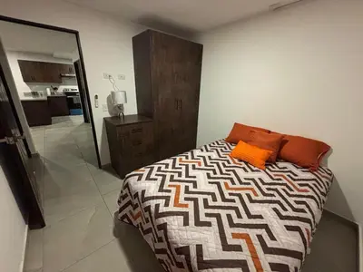 a bedroom with a bed with orange pillows on it at Apartamento Nuevo ,Todo a tu alcance in San Salvador