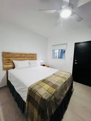 a bedroom with a large white bed with a wooden headboard at Room 7 Ciudad Jardin in San Miguel