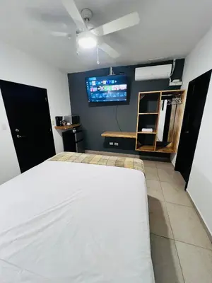 a bedroom with a bed and a tv on the wall at Room 7 Ciudad Jardin in San Miguel