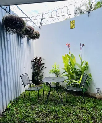 a patio with two chairs and a table and some plants at Room 7 Ciudad Jardin in San Miguel