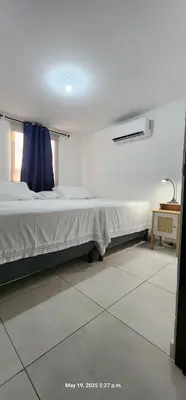 a bedroom with a bed with a blue curtain at La Joya de Opico in San Juan Opico