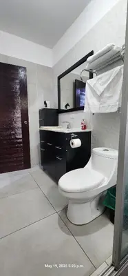 a bathroom with a toilet and a sink and a mirror at La Joya de Opico in San Juan Opico