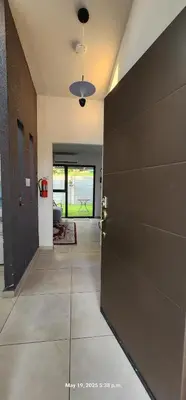 a hallway with a black door and a room at La Joya de Opico in San Juan Opico