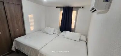a small bed in a small room with a window at La Joya de Opico in San Juan Opico