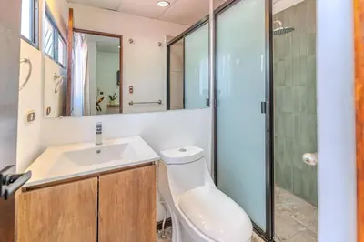 a bathroom with a toilet and a sink and a shower at Casa Lúmina - Hotel Boutique, San Benito in San Salvador