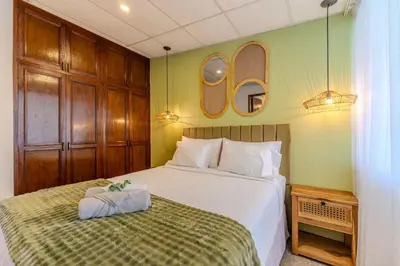 a bedroom with a bed and two mirrors on the wall at Casa Lúmina - Hotel Boutique, San Benito in San Salvador
