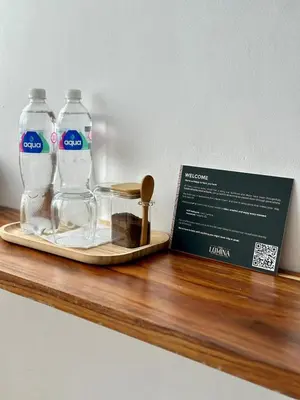 two bottles of water and a box on a wooden shelf at Casa Lúmina - Hotel Boutique, San Benito in San Salvador