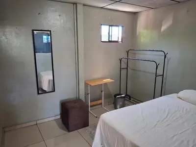 a bedroom with a bed and a mirror and a table at Habitación sencilla in San Salvador
