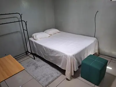 a small room with a bed and a green stool at Habitación sencilla in San Salvador
