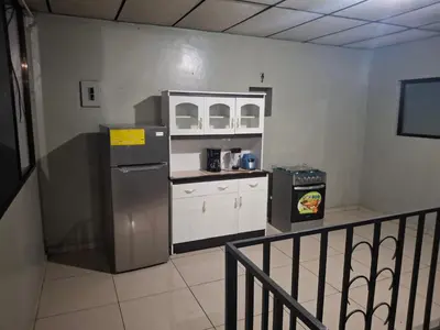 a kitchen with a refrigerator and a counter top at Habitación sencilla in San Salvador