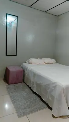 a white bedroom with a bed and a mirror at Habitación sencilla in San Salvador