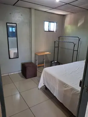 a bedroom with a bed and a table and a mirror at Habitación sencilla in San Salvador