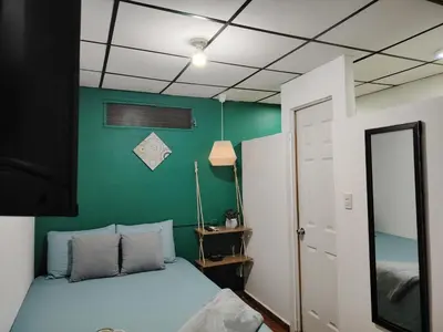 a bedroom with a bed and a green wall at Rancho Los Hernandez - Surf City - El Tunco in Tamanique