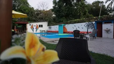 a patio with a table and chairs and a pool at Rancho Los Hernandez - Surf City - El Tunco in Tamanique