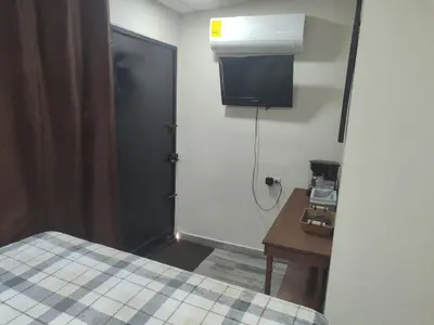 a room with a bed and a desk and a door at Estancia WLC