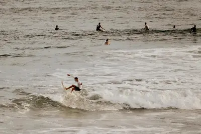 a man riding a wave on a surfboard in the ocean at Surfside El Tunco in Tamanique