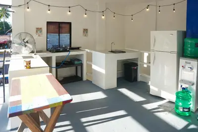 a kitchen with white counters and a refrigerator at Surfside El Tunco in Tamanique