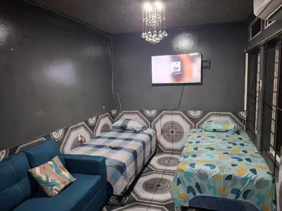a room with two beds and a couch and a tv at Mini apartamento familiar in San Salvador