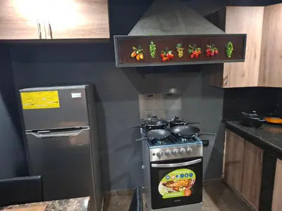 a kitchen with a stove and a refrigerator at Mini apartamento familiar in San Salvador