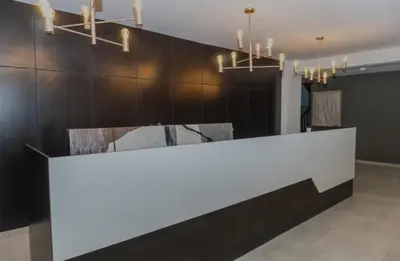a lobby with a reception desk and two chandeliers at Un lugar especial en San Salvador in San Salvador