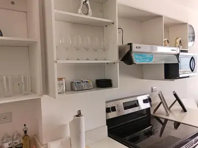a kitchen with white cabinets and a stove top oven at Un lugar especial en San Salvador in San Salvador