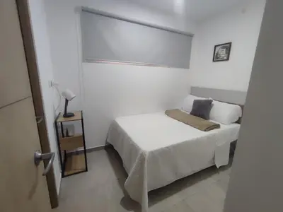 a white bedroom with a bed and a window at Un lugar especial en San Salvador in San Salvador