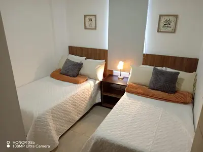two twin beds in a room with a night stand at Un lugar especial en San Salvador in San Salvador