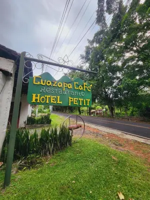 a sign for a hotel on the side of a road at Guazapa Cafe hotel petit in Suchitoto