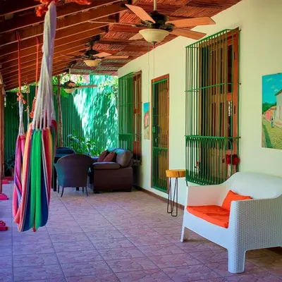 a porch with a hammock and a living room at Guazapa Cafe hotel petit in Suchitoto