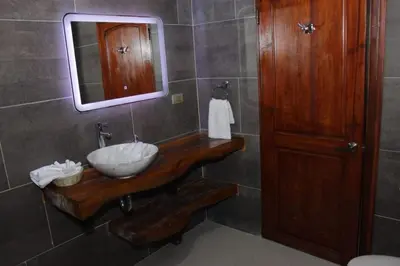 a bathroom with a sink and a mirror at Guazapa Cafe hotel petit in Suchitoto
