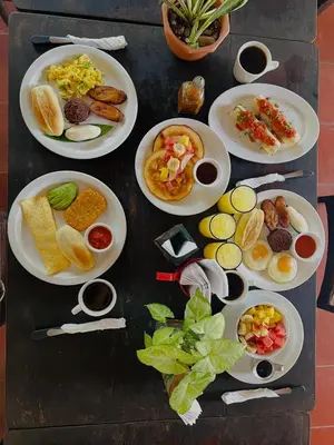 a table with plates of breakfast foods on it at Guazapa Cafe hotel petit in Suchitoto