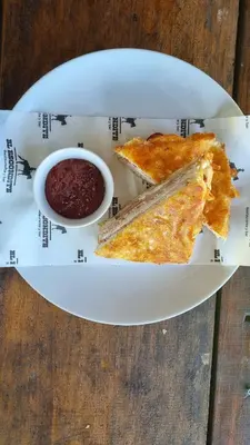 a plate with two slices of pizza and a bowl of salsa at Las Cabañitas, el boqueron in San Salvador