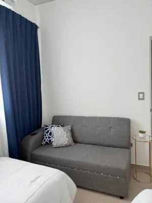 a couch sitting in a room with blue curtains at Elegante casa a minutos de Centro comercial in San Miguel