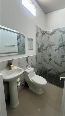 a bathroom with a toilet and a sink at Elegante casa a minutos de Centro comercial in San Miguel