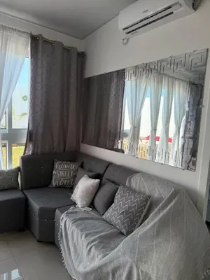 a living room with a gray couch and windows at Elegante casa a minutos de Centro comercial in San Miguel