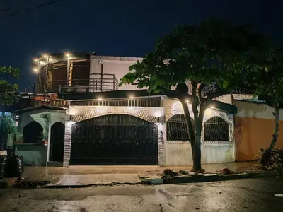 a building with a gate and a tree in front of it at Casa Miralvalle in San Salvador