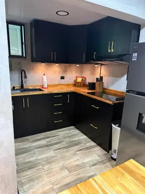 a kitchen with black cabinets and a tile floor at Casa Miralvalle in San Salvador