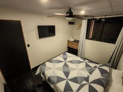 a bedroom with a bed and a flat screen tv at Casa Miralvalle in San Salvador