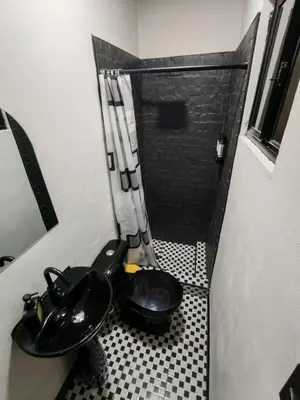 a bathroom with a black toilet and a shower at Casa Miralvalle in San Salvador