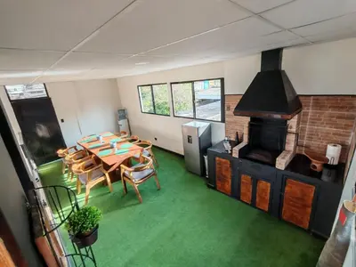 a room with a table and chairs and a fireplace at Casa Miralvalle in San Salvador