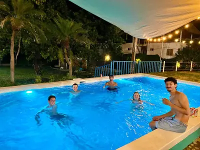 a group of people in a swimming pool at night at Sunzal Surf Garden - El Tunco in Tamanique
