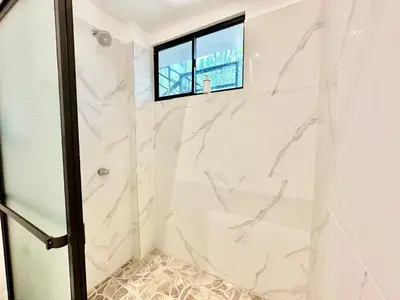 a bathroom with a shower with a window at Sunzal Surf Garden - El Tunco in Tamanique