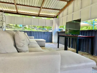 a living room with a couch and a flat screen tv at Sunzal Surf Garden - El Tunco in Tamanique