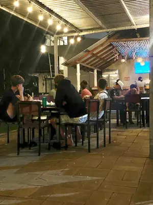 a group of people sitting at a table in a restaurant at Sunzal Surf Garden - El Tunco in Tamanique